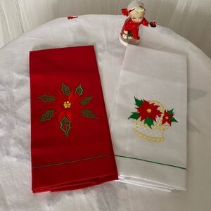 A pair of brand new tea towels! One white with red poinsettias, one red